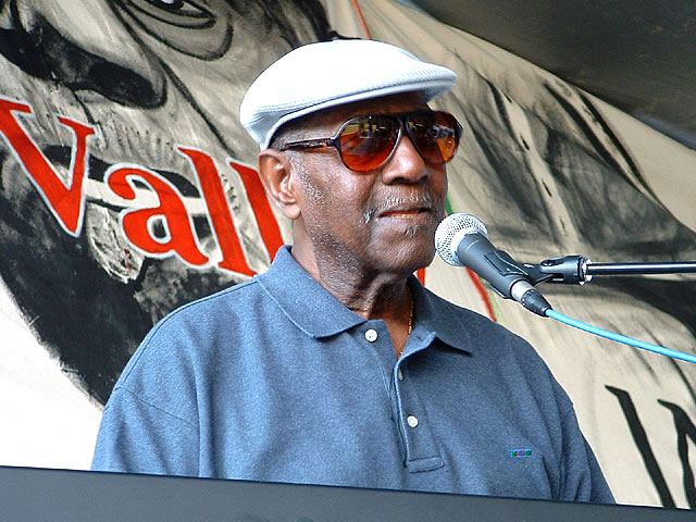 African American man dressed in a blue shirt and white hat