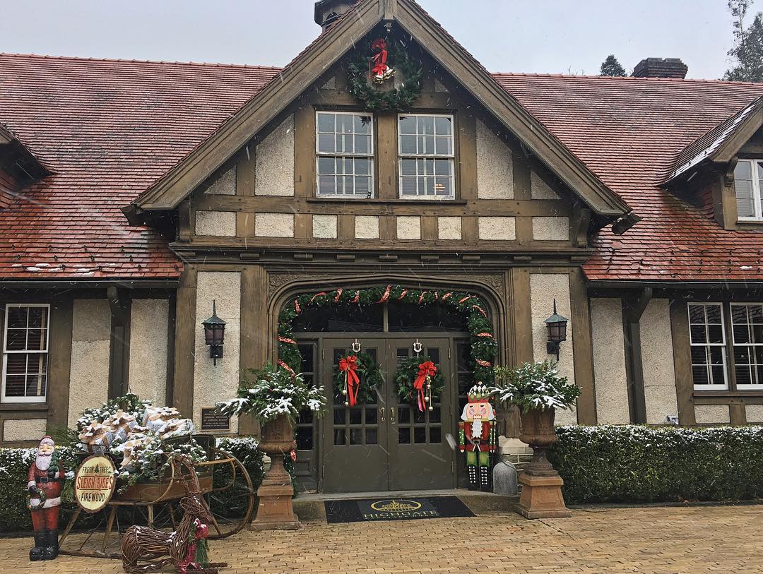tudor looking building decorated with pine and Santas