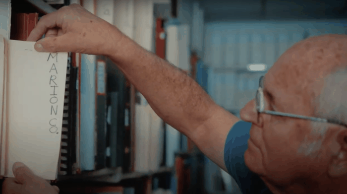 older gentleman looking through files on a shelf