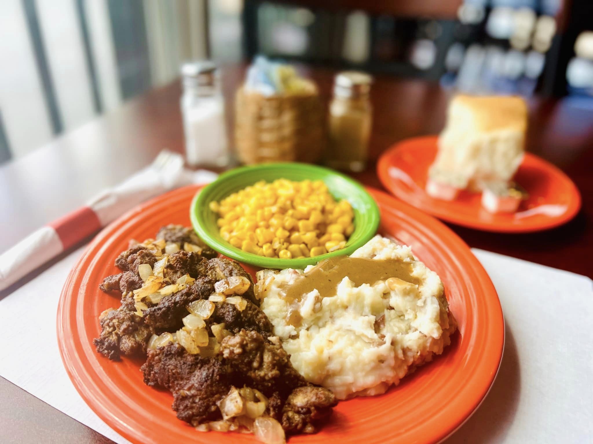 plate of food with roast, mashed potatoes and corn