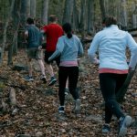 two men and two women running on trail with orange leaves on the ground. Saw whet owls Wv bird banding West Virginia owls EHQ valley falls endurance headquarters valley falls 